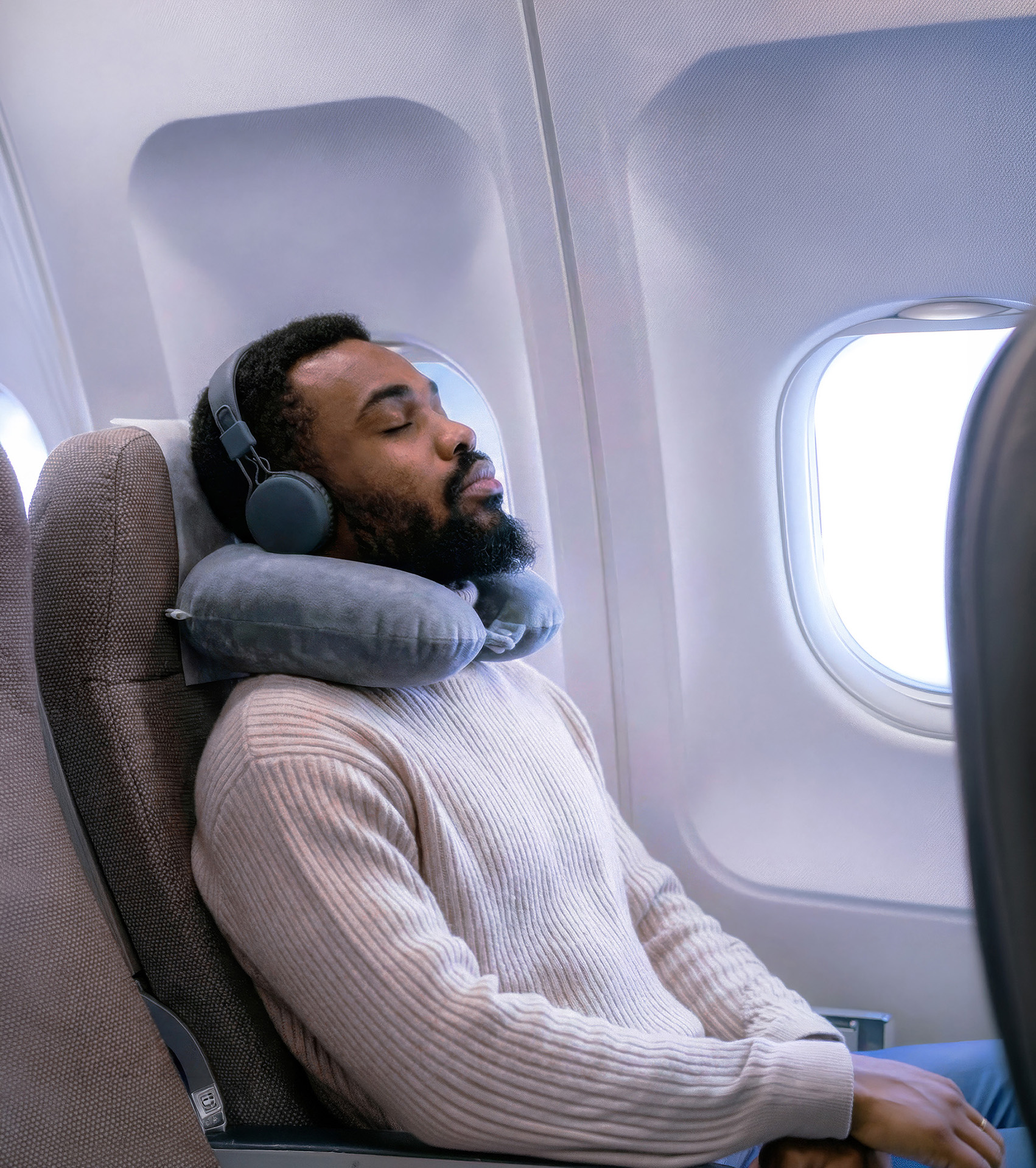 Man listening with headphones on a plane